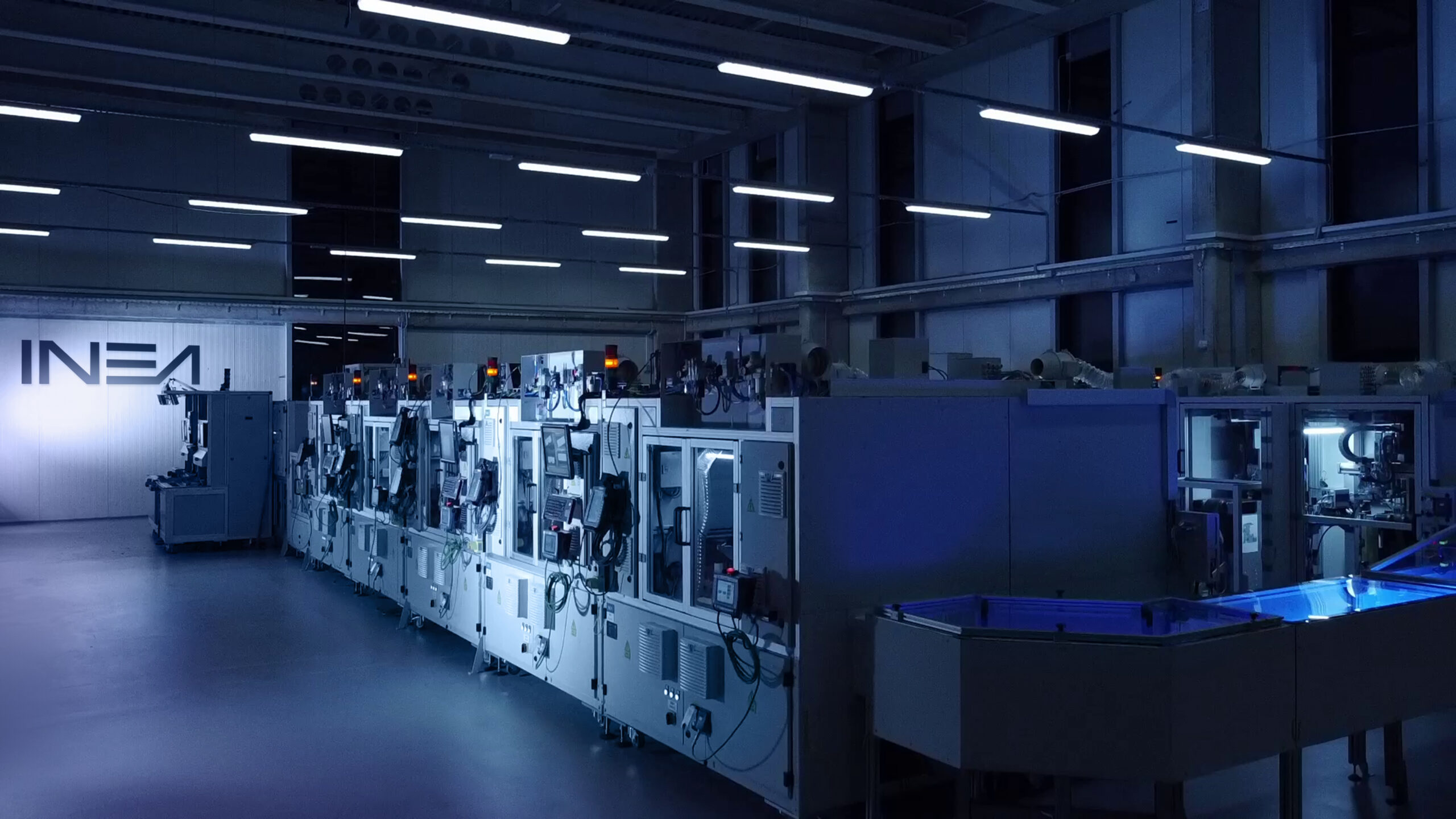 Photo of a display assembly line on the workshop floor with a logo in the background